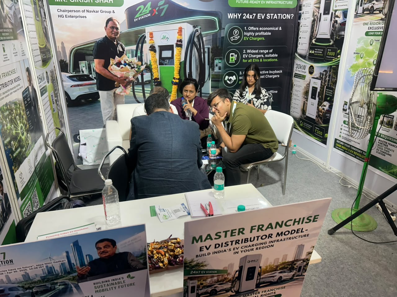 24x7 EV Station exhibition booth during a visitor discussion